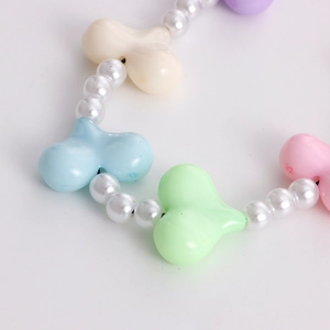 Macro shot of colorful acrylic beads and pearls on heart-themed phone charm lanyard
