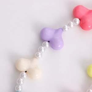 Detailed macro view of colorful heart acrylic beads and white pearls on phone charm cord