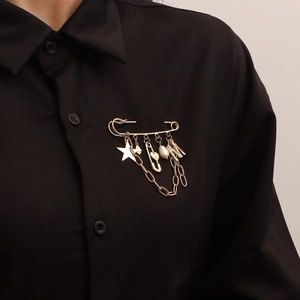 Vintage gold safety pin brooch with star, M pendant, and pearl on black shirt