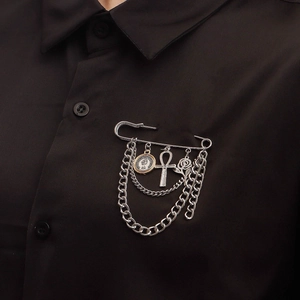 Silver punk safety pin brooch with rose, ankh cross, coin charms and tassels on black shirt
