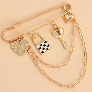 Vintage gold safety pin brooch with checkerboard lock, heart charms and double chains