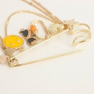 Vue détaillée d'une broche épingle dorée avec pendentifs sourire jaune et cœur