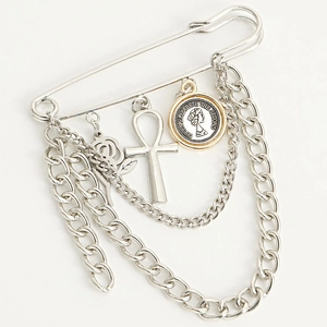 Detail of silver safety pin brooch with rose, Ankh cross, and queen portrait coin pendants