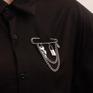 Silver punk style safety pin brooch with hanging key and padlock charms on black shirt