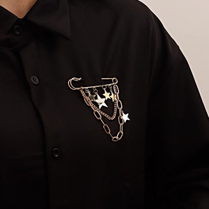 Broche punk dorée avec épingle de sûreté, chaînes à franges et étoiles sur une chemise noire