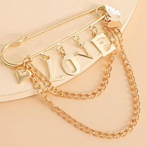 Detailed close-up of gold LOVE letter charms and butterfly pendants on a double-layer brooch