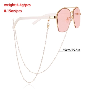 Pink sunglasses with gold metal frame and pearl strap chain on white background