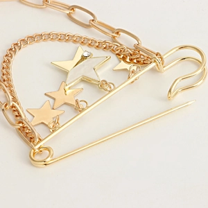 Vue détaillée de la broche étoile dorée avec chaînes et détails en strass brillant
