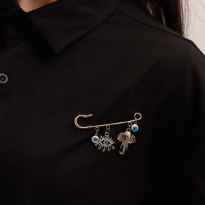 Golden Evil Eye safety pin brooch with elephant charm on black jacket lapel
