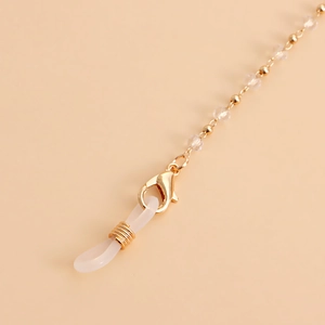 Macro detail of gold glasses chain with crystal beads, lobster clasp and silicone loop