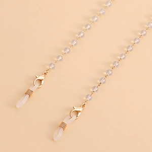 Detail of beaded eyewear strap with white pearls and gold lobster clasps
