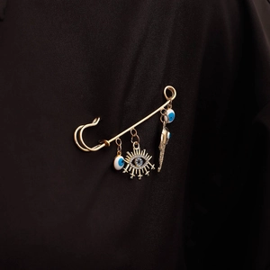 Gold evil eye safety pin brooch with rhinestones on black suit jacket lapel
