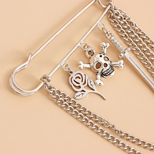 Detail of gothic silver brooch with skull, sword, rose charms and layered fringe chains
