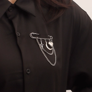 Silver safety pin brooch with layered chains featuring heart moon and star pendants