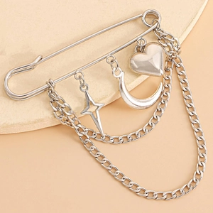 Close-up of silver brooch with heart, crescent moon, star charms and layered chains