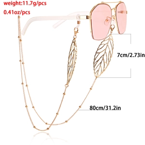 Lunettes de soleil roses avec chaîne en métal doré et pendentifs en forme de feuille