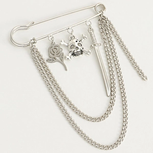 Detail of silver skull and rose charms on a multi-layered tassel punk safety pin brooch