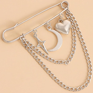 Silver-tone safety pin brooch featuring heart, moon, and star charms with layered snake chains