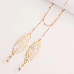 Détail de la chaîne à lunettes dorée avec pendentifs feuilles et boucles en silicone