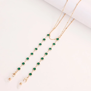 Golden eyewear chain with green crystals and silicone loops on a white background