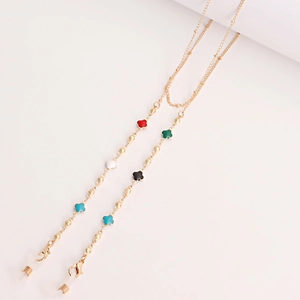 Detail of gold beaded eyewear chain with colorful four-leaf clover enamel charms