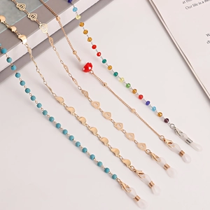 Dettaglio di catenine per occhiali alla moda con cuori in metallo, perline turchesi e moschettoni