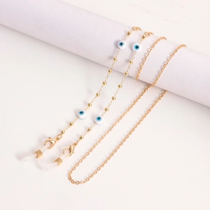 Macro detail of golden metal glasses chain with blue evil eye beads and lobster clasp