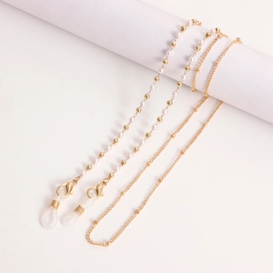 Detail of gold eyewear chain with white pearls, lobster clasp and silicone loops