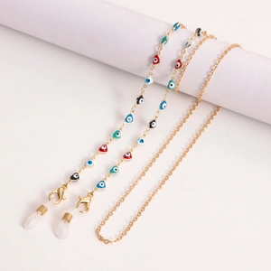 Detail of gold metal eyewear chain with multi-colored heart-shaped evil eye charms