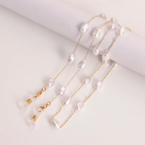 Détail d'une chaîne dorée élégante avec perles blanches et boucles pour lunettes