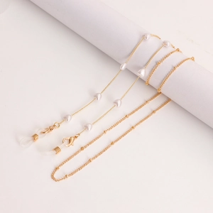 Detail van de gouden metalen ketting met witte hartkralen voor bril of masker