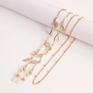 Détail de chaîne à lunettes dorée avec pendentifs feuilles et boucles antidérapantes