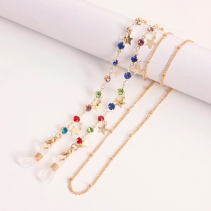 Chaîne de lunettes colorée avec étoiles dorées et perles cristal sur socle blanc