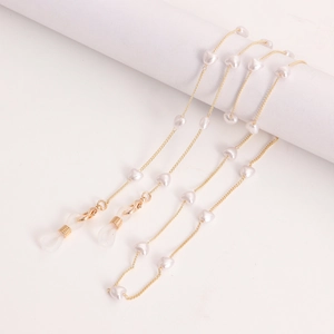 Detail of gold eyewear chain with white heart-shaped pearls and silicone loops
