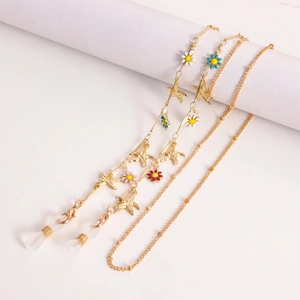 Détail de chaînes de lunettes dorées avec marguerites en émail et étoiles de mer