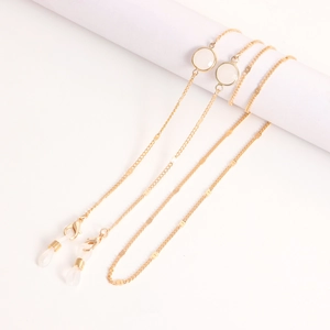 Détail de la chaîne de lunettes dorée avec perles translucides et boucles en silicone