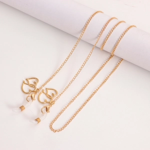 Détail d'une chaîne de lunettes dorée avec pendentifs en cœur et fermoirs mousquetons