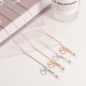 Détail de chaînes de lunettes avec pendentifs cœur en finitions or, argent et rose