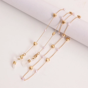 Close-up of golden chain with heart charms and pink pearls for glasses or masks