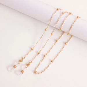 Close-up of golden beaded eyewear chain with lobster clasp and silicone loop