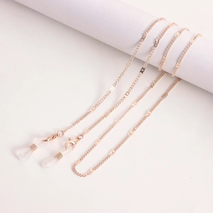 Elegante roségoldene Metallkette für Brillen und Masken mit Karabinern auf beigem Grund