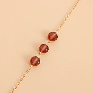 Elegante catenella per maschera dorata con perle di cristallo ambra scuro su maglie in metallo
