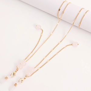 Close-up of golden spectacle chain with pink translucent beads and silicone loops