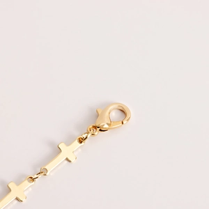 Détail de la chaîne de taille croix en métal doré poli avec fermoir mousqueton sûr