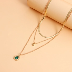 Detail van gelaagde gouden slangenhalsketting met groene agaat hanger voor vrouwen