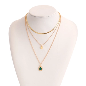Detail van de gouden gelaagde ketting met platte slangenketting en groene agaat druppelhanger