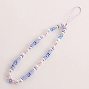 Detail showing handmade phone charm with purple clay beads and white faux pearls