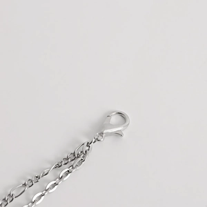 Macro shot of a silver punk lobster clasp and figaro metal chain waist belt accessory