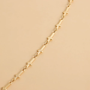 Ceinture chaîne dorée minimaliste avec petits charms en forme de croix en métal poli