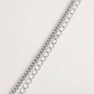 Detailed comparison of silver metal curb chain and cable chain textures on a white surface